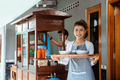 Portrait of young woman standing at home