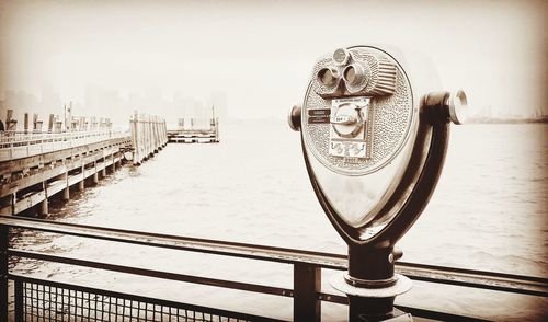 Close-up of coin-operated binoculars against cityscape