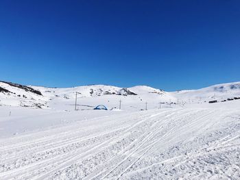 Scenic view of snowcapped mountains against clear blue sky