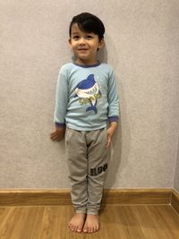 Portrait of boy standing on hardwood floor