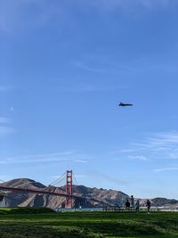 Airplane flying over mountain against sky