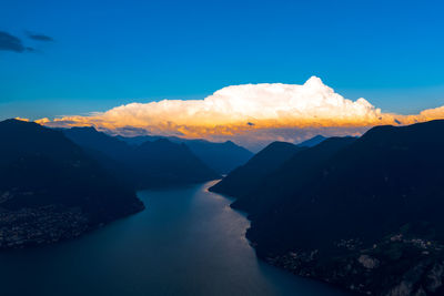 Scenic view of sea and mountains against blue sky