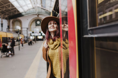 Smiling woman standing at entrance of train
