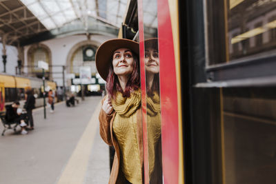 Portrait of young woman standing in bus