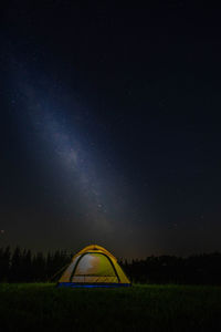 Tent on field against star field at night