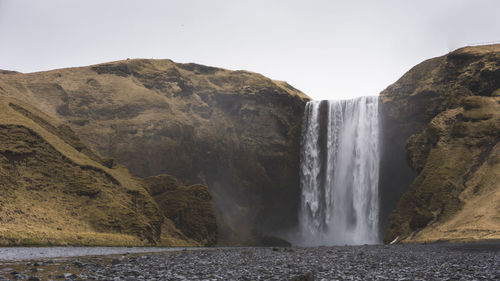 Scenic view of waterfall against sky