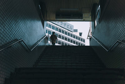 Low angle view of man walking on staircase