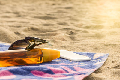 High angle view of sunglasses and mobile phone on beach