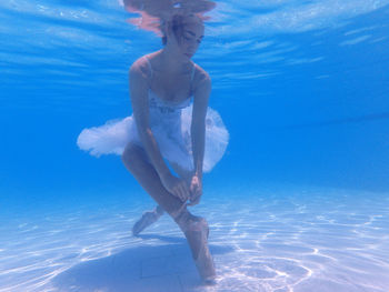 Ballerina wearing ballet shoe in swimming pool