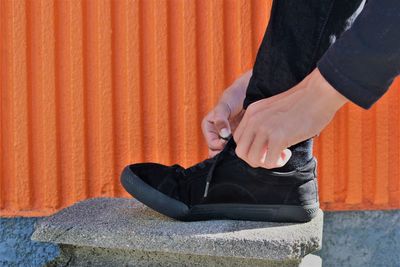 Low section of woman sitting on sidewalk