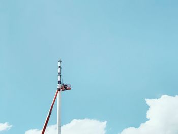 Low angle view of communications tower against blue sky