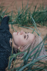 Portrait of woman lying down on field