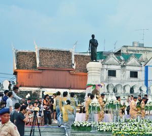 People standing on town square against sky