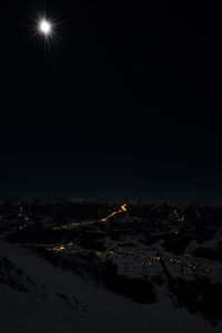 Illuminated city against clear sky at night