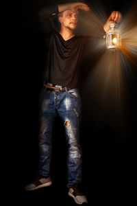 Portrait of man standing against illuminated light