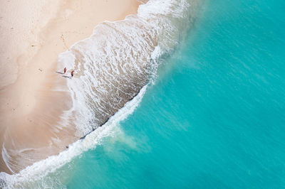 Aerial view of man and woman walking at beach