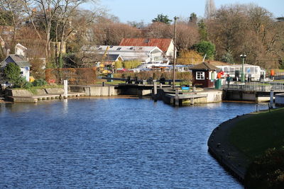 Houses by river against sky