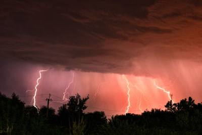 Panoramic view of lightning over landscape against sky at night