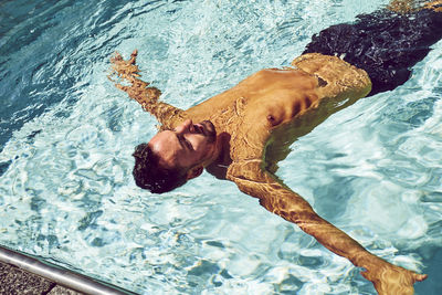 An overhead view of a man floating in a pool.