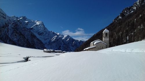 Scenic view of snowcapped mountains against blue sky