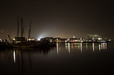 Boats moored in harbor at night