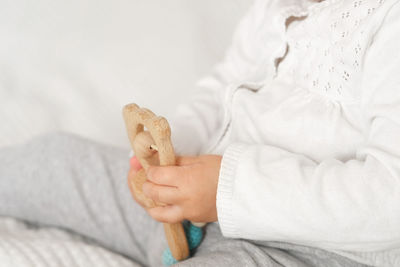 Cute baby girl playing tactile wooden and silicone toys. young child hand plays sensory massage ball