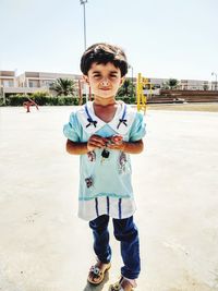 Portrait of boy standing against sky