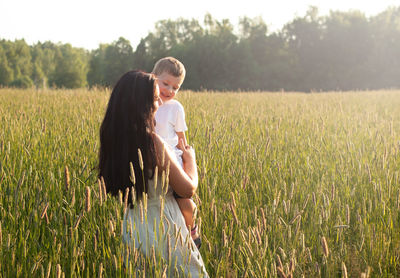 Mother holds her son in her arms and hugs. happy family and parental love concept