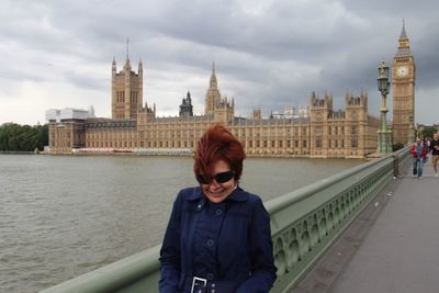 Woman in sunglass on westminster bridge over thames river in city