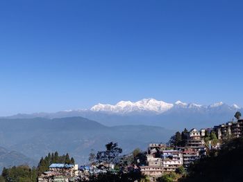 Buildings in city against clear blue sky