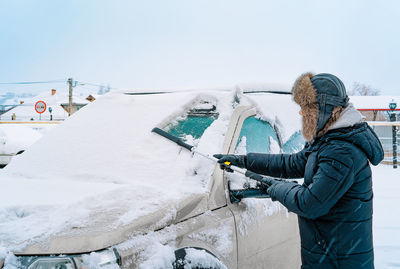 Rear view of man standing on snow covered landscape