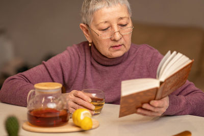 Portrait of young woman having food on table