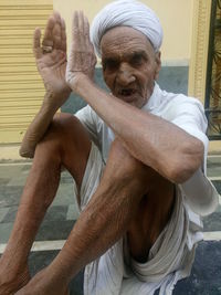 Portrait of senior man sitting outside house