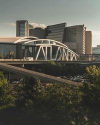 Bridge over river by buildings against sky