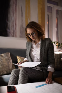 Young woman sitting on sofa at table