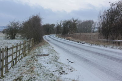 Snow covered road against sky