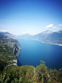 Scenic view of lake and mountains against blue sky