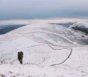 Woman standing on snow covered landscape