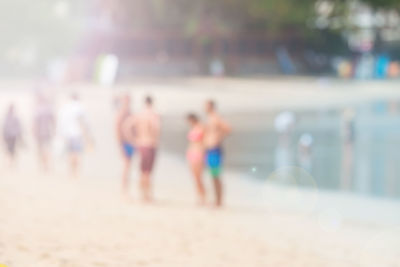 Close-up of people at beach against sky