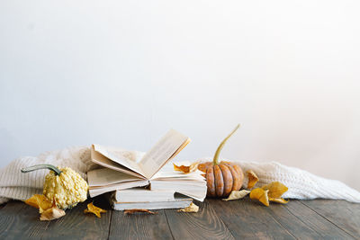 Reading in the autumn day. cozy autumn background, decorative pumpkin, dried flowers, books.