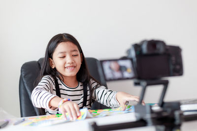 Portrait of a smiling girl sitting on table