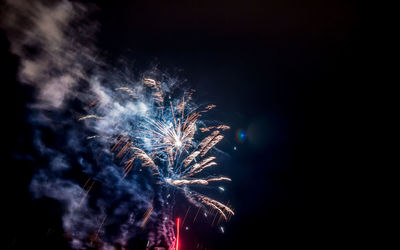 Firework display against sky at night