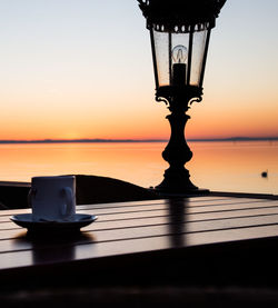 Close-up of water on table against sea during sunset