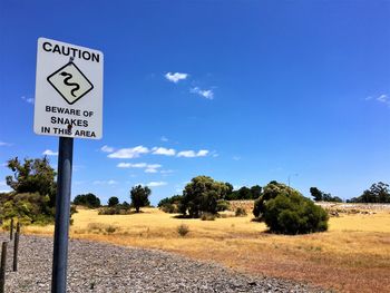 Road sign against blue sky