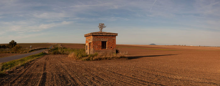 Built structure on field against sky