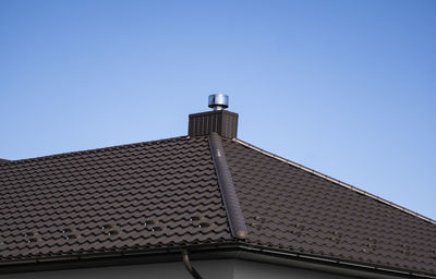 Low angle view of building roof against clear sky