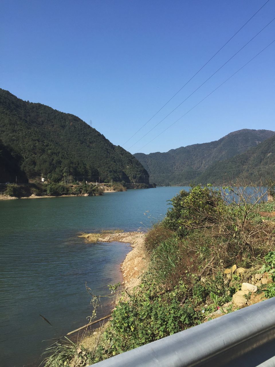 mountain, clear sky, water, blue, copy space, tranquil scene, scenics, mountain range, beauty in nature, sea, tranquility, nature, lake, river, day, plant, idyllic, outdoors, tree, no people