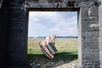 Scenic view of field against sky seen through fortress opening