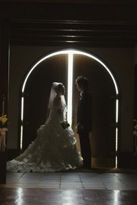 Side view of newlywed couple standing at entrance in church