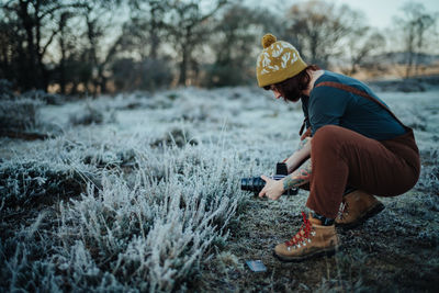 Full length of woman photographing grass